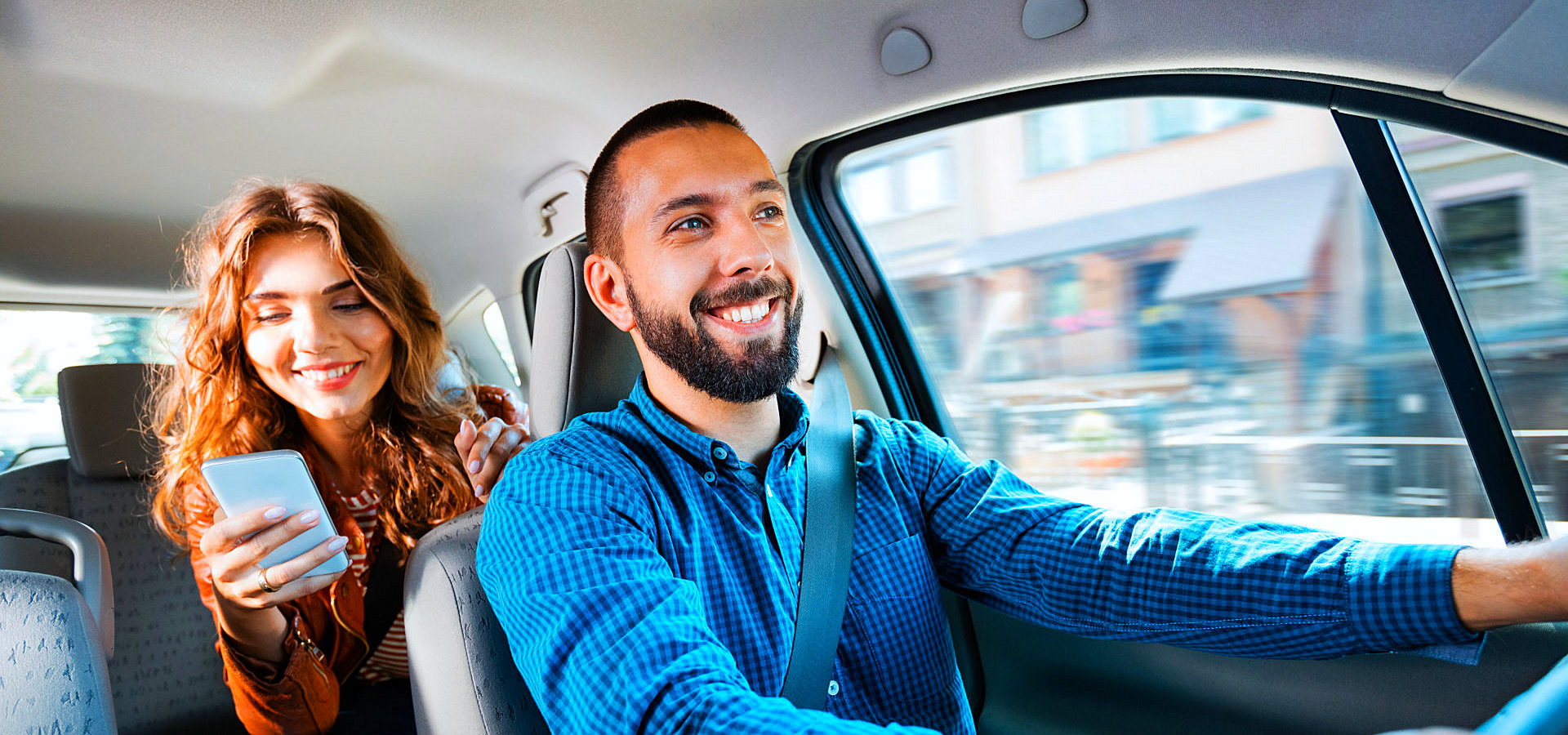 male driver with female passenger smiling